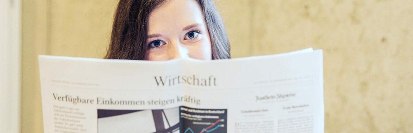 Person holding an open magazine with a chart and German text.