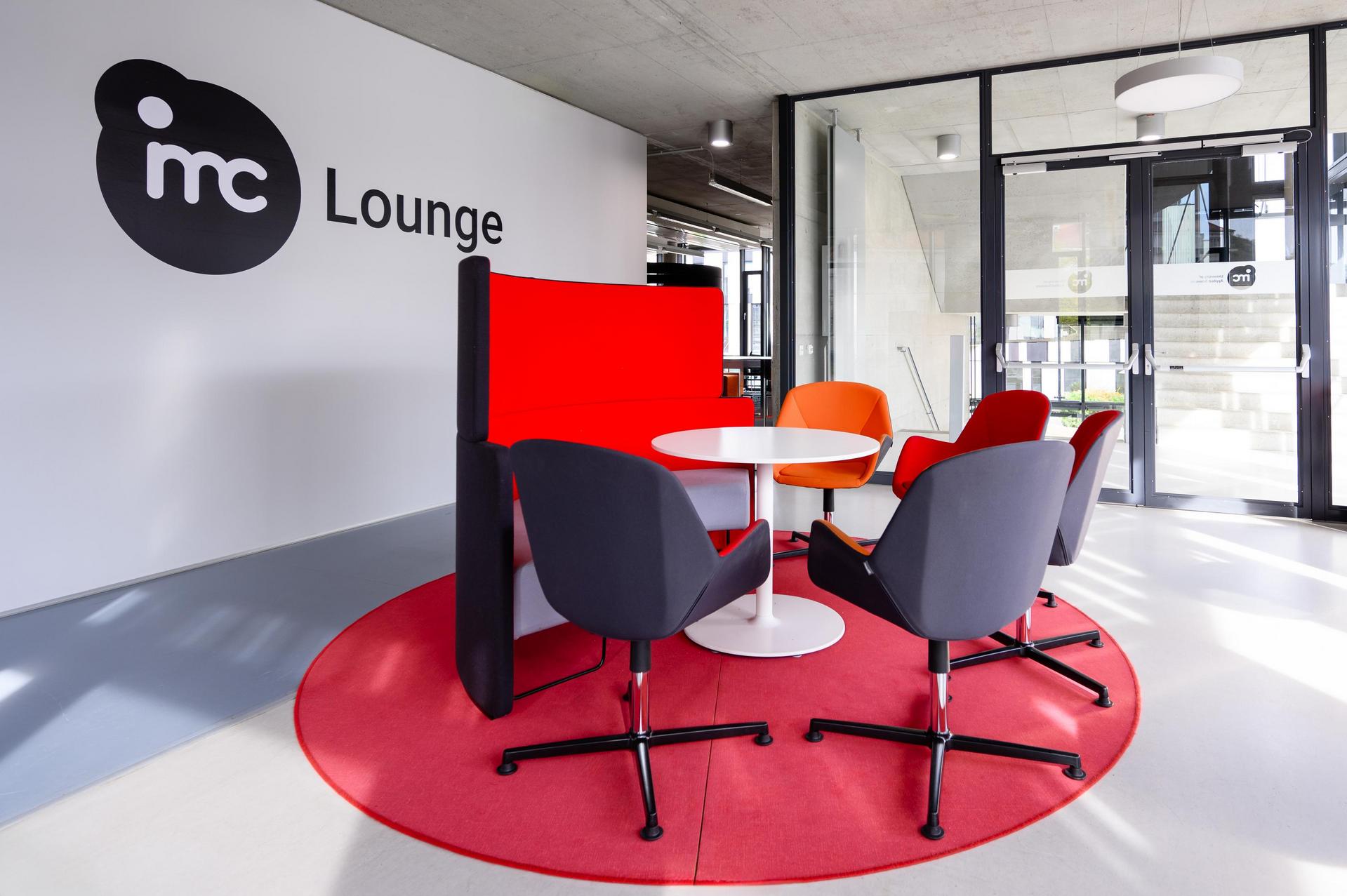 Die IMC Study Lounge mit Sesseln, Bänken und Tischen.