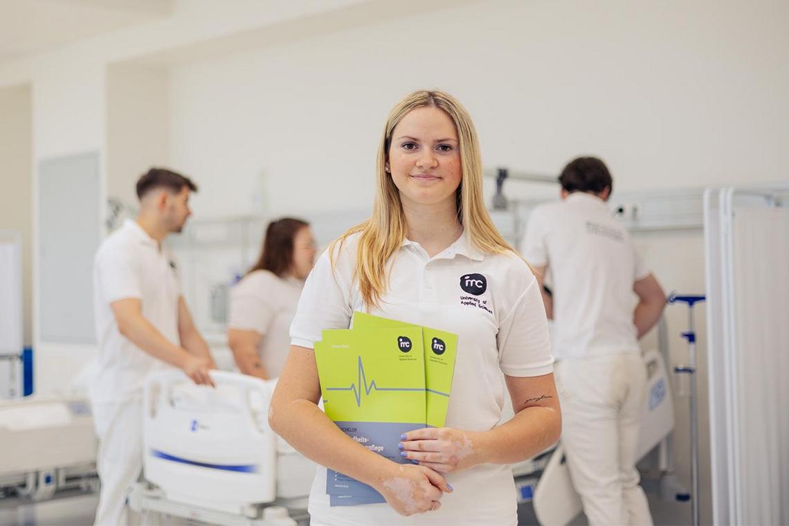 Porträt von Hannah Schodl, die vor einem Krankenbett steht