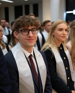 Gruppe von Personen in formeller Kleidung bei einer Sponsion.