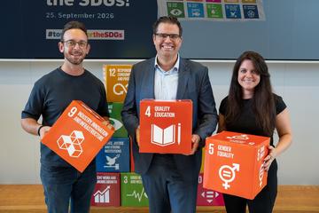 3 Personen halten SDG Würfel