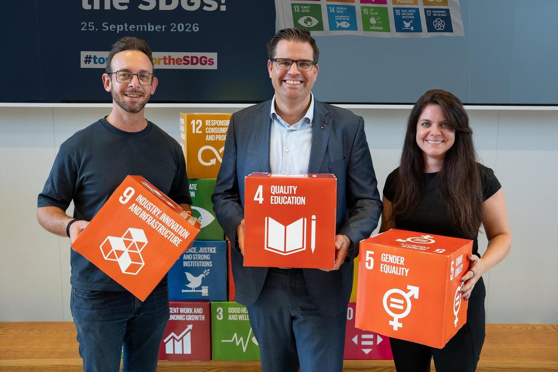 3 Personen halten SDG Würfel