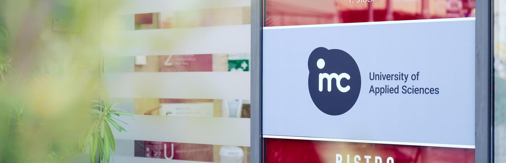 Entrance to Bistro Gozzo within the IMC Krems building, featuring the Federal Monuments Office and IMC Krems logos in the foreground
