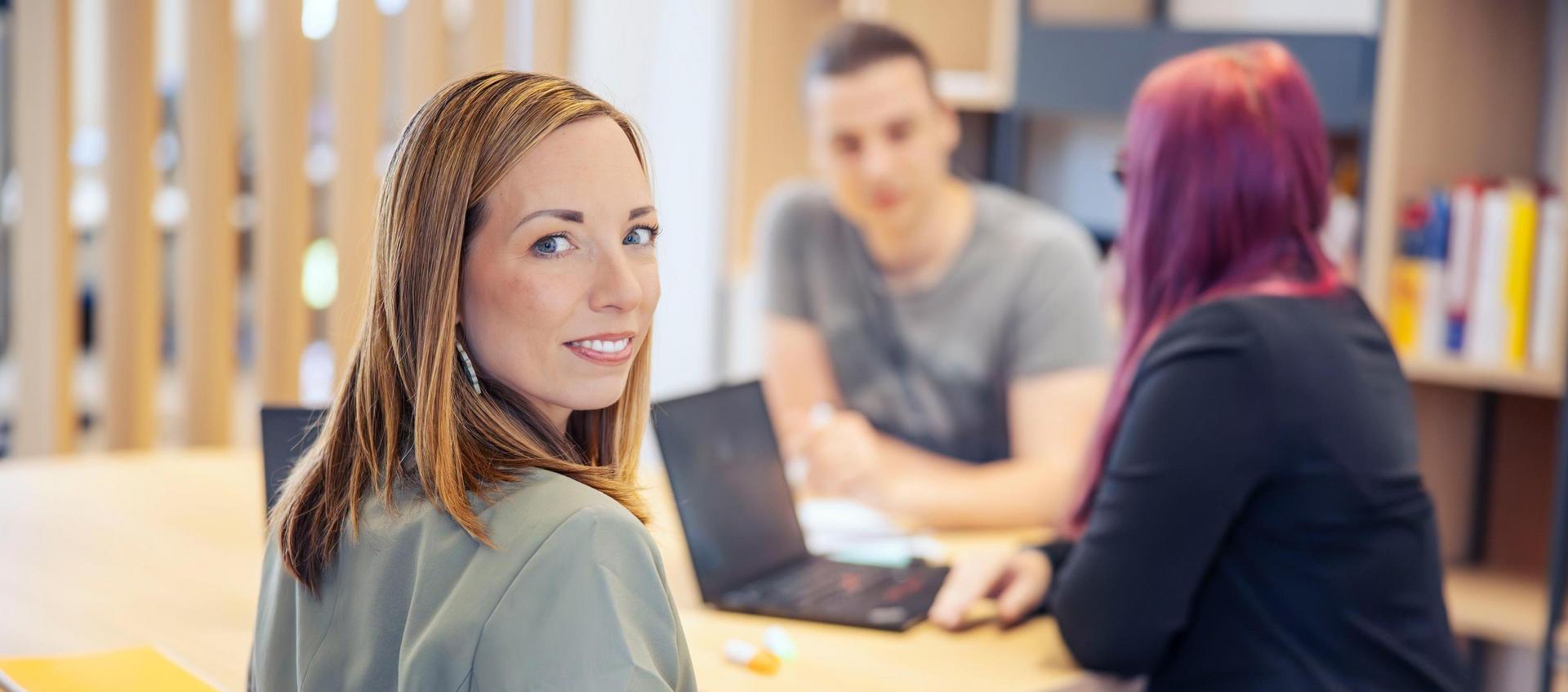 Zwei Personen sitzen sich in einem Café gegenüber und führen ein Gespräch.