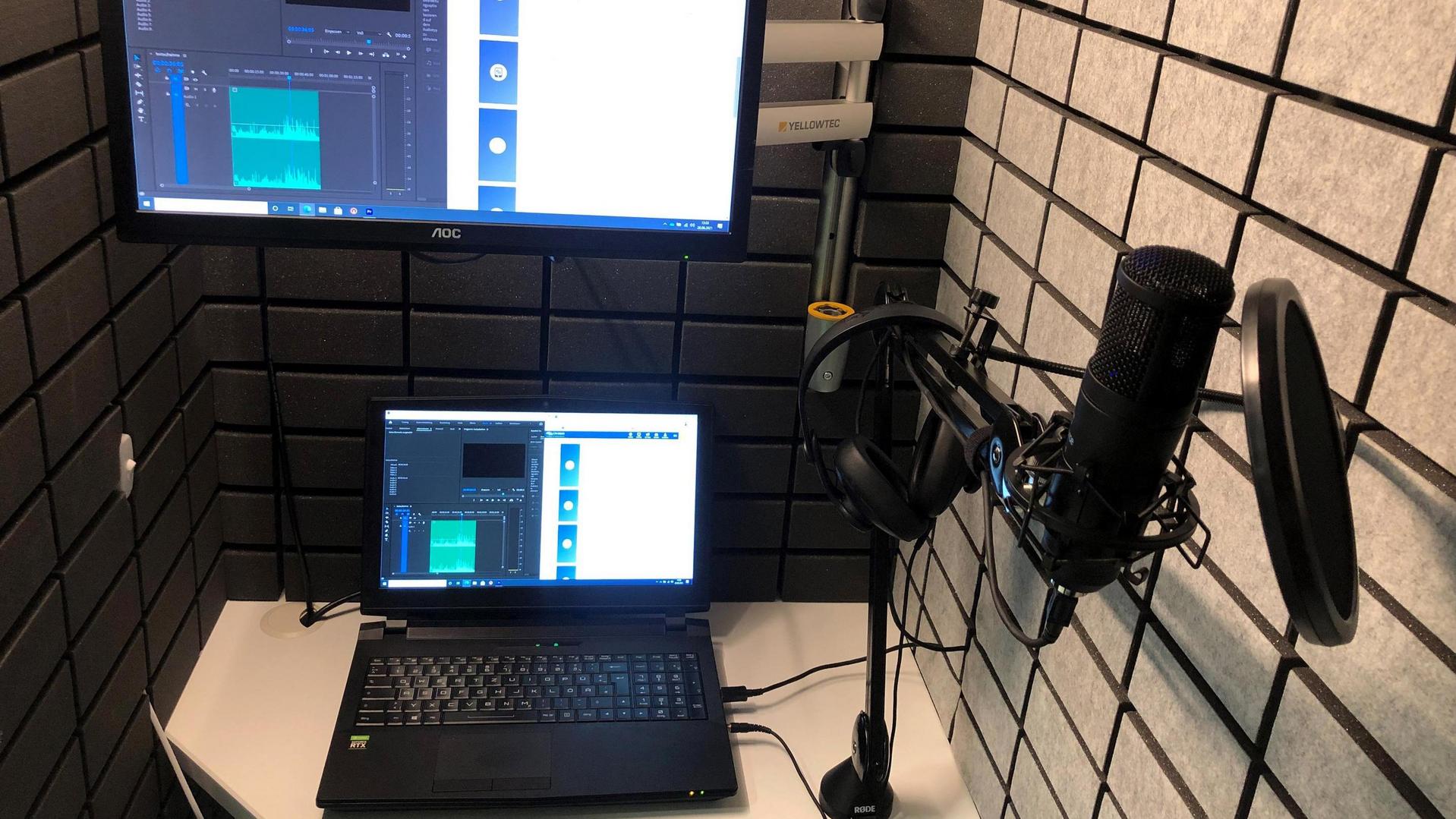 Studio-Setup mit Laptop, Mikrofon und Audio-Interface auf einem Schreibtisch
