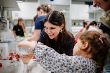 Eine Mitarbeiterin und ein Kind im Labor