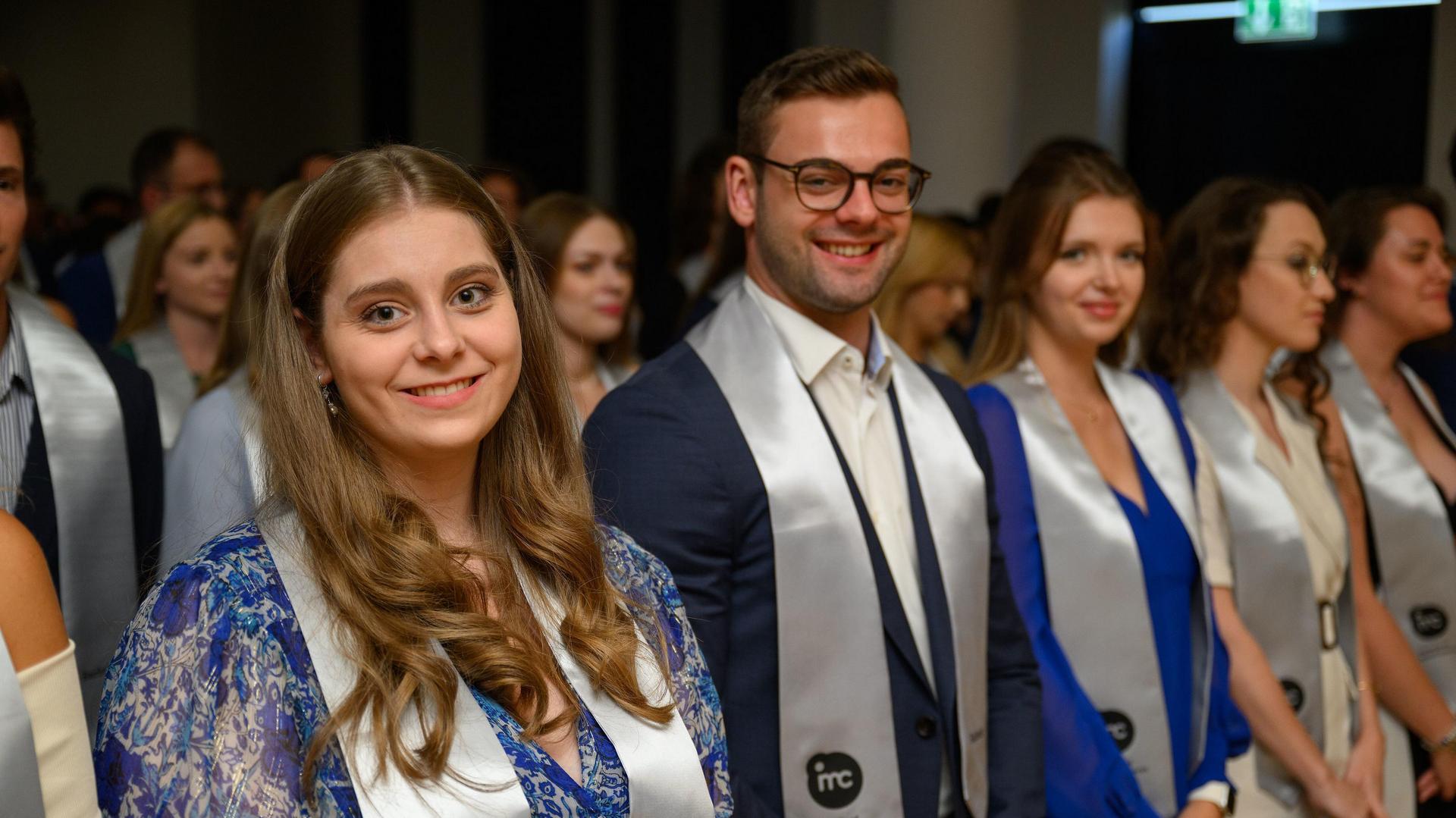 Group of individuals in formal attire at a graduation ceremony