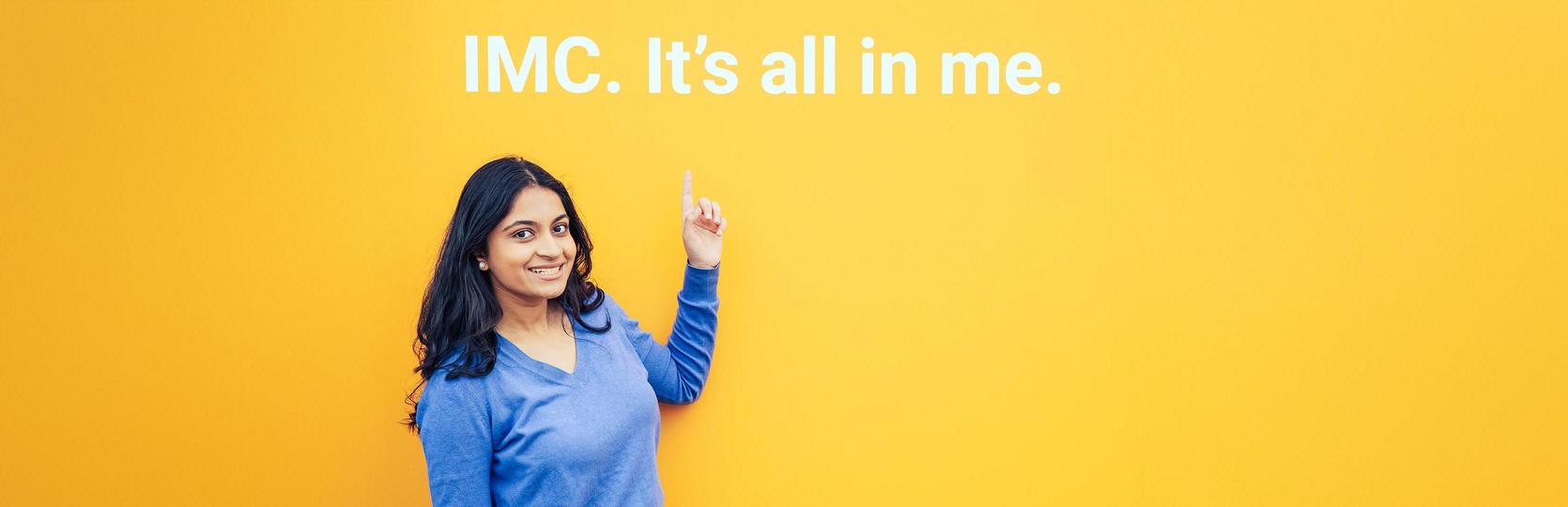 Person in blauem Oberteil vor gelbem Hintergrund zeigt auf den Schriftzug IMC. It’s all in me.