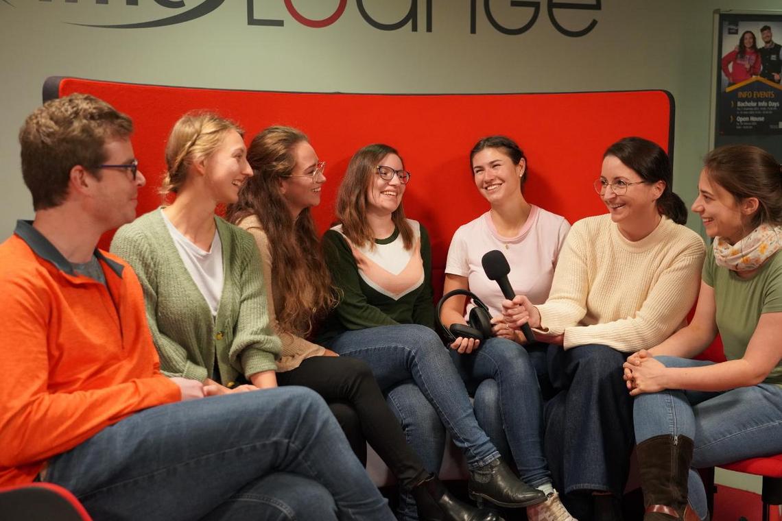 Studierende mit Mikrofon sitzen in der Study Lounge.